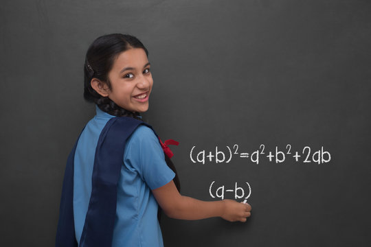 Rural school girl writing formula on a blackboard - Powered by Adobe