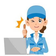 サムズアップのサインを出しパソコンを操作する青色の作業着の女性
