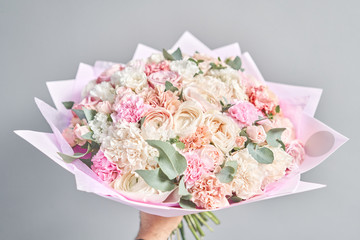 European floral shop. Beautiful bouquet of mixed flowers in hands. the work of the florist at a flower shop. Delivery fresh cut flower.