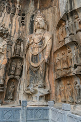 Fototapeta na wymiar Big Bodhisattvas statue made in tang dynasty. The figure is the king of heaven, Fengxian main cave. Longmen Grottoes in Luoyang, Henan province, China