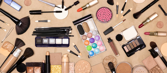 Big set of various makeup products and accessories on kraft paper background. Make-up table. Top view, flat lay