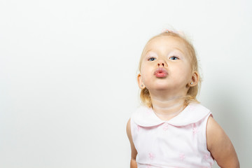 Little girl blows a kiss on a light background. Banner. Concept little model, princess