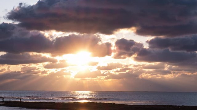 Red sunsets over sea video 4K. The sun touches horizon. Red sky, yellow sun and amazing sea. Summer sunset seascape. The sun in spindrift clouds Fantastic natural sunsets