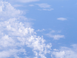Beautiful view from airplane window above the clouds. Bright blue sky and white clouds. Skyline background with copy space.