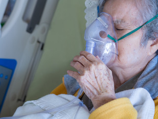 Close-up of elderly woman patients with lung disease, getting oxygen for treatment in the room at...