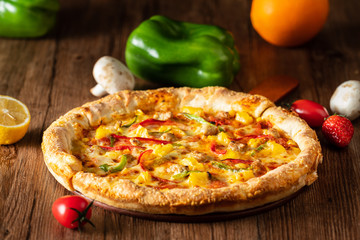 whole italian pizza on wood table with ingredients