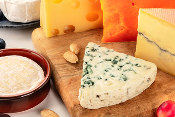 Cheese platter. Blue cheese, goat cheese, red and Dutch ones, a close-up on a wooden board