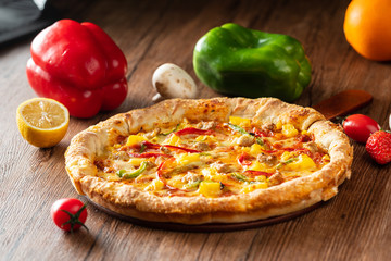 whole italian pizza on wood table with ingredients