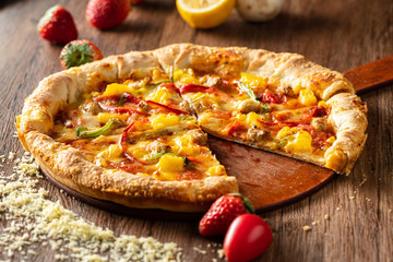 whole italian pizza on wood table with ingredients