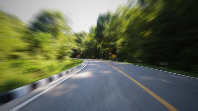 Time-lapse journey on the countryside road fast movement speed in the rural place with wood and forest with motion blur effect