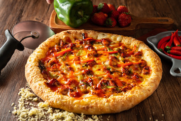 whole italian pizza on wood table with ingredients