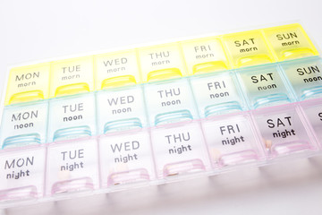 Organizer for medical pills on a white isolated background close-up. Organization of taking pills...