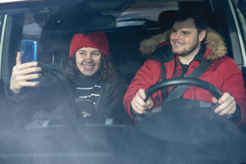 couple in car in winter outfit driving and talking