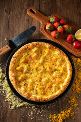 whole italian pizza on wood table with ingredients