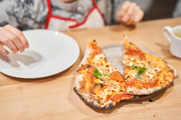 Pizza Margarita Heart-shaped for Valentine's day.. Baked tasty margherita pizza in Traditional wood oven in Neapolitan restaurant, Italy.
