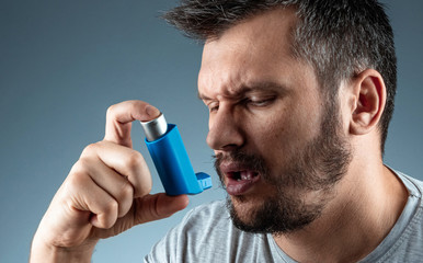 Portrait of a man with an asthma inhaler in his hands, an asthmatic attack. The concept of...