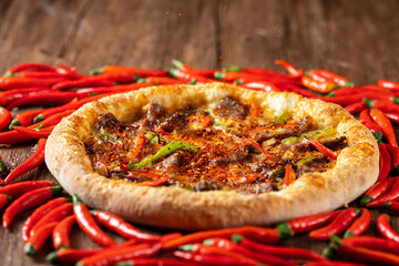 whole italian pizza on wood table with ingredients