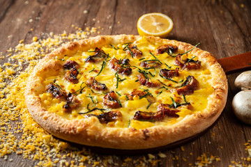 whole italian pizza on wood table with ingredients