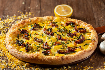 whole italian pizza on wood table with ingredients