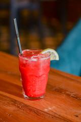 Classic alcoholic summer cocktail with lemon and mint garnish on a bar table.