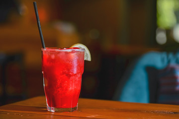 Classic alcoholic summer cocktail with lemon and mint garnish on a bar table.