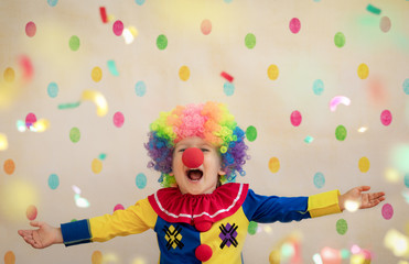 Funny kid clown playing indoor