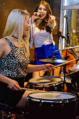 Woman singing, band playing instruments.