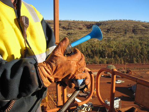 Male Rigger Hand Wearing A Safety Glove Using A Signal Air Horn To Direct A Crane Operator While Working At Construction Site Perth Australia 