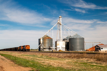 Fototapeta na wymiar BNSF Railway train in agricultural landscape with silo, Claude, Texas