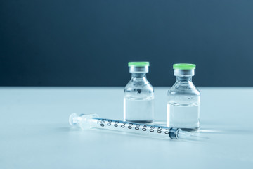 Vaccine in vial and syringe close-up on a white table gray background, medical concept, laboratory,...