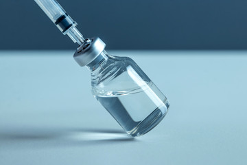 Vaccine in vial and syringe close-up on a white table gray background, medical concept, laboratory, subcutaneous injection vaccination, dose. Disease treatment immunization. - obrazy, fototapety, plakaty