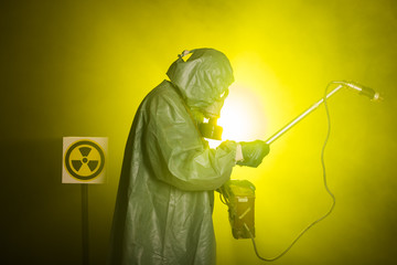 Radiation and danger concept - Man in old protective hazmat suit - obrazy, fototapety, plakaty