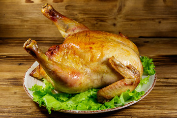 Baked whole chicken on a wooden table
