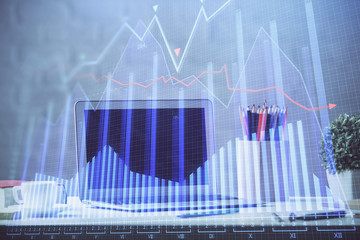 Financial graph colorful drawing and table with computer on background. Multi exposure. Concept of international markets.
