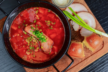 Traditional Ukrainian Russian vegetable borscht. Ukrainian beetroot soup in a bowl with meet, greenery and garlic bread