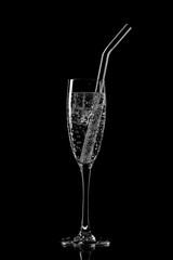 Glass of sparkling water soda drink with ice on black background
