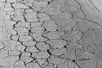 Texture of gray cracked asphalt. Abstract backdrop for design.