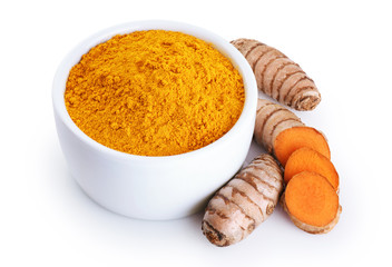 Turmeric root and bowl with turmeric powder isolated on white background.