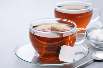 Cup of tea with tea bag on a gray background.