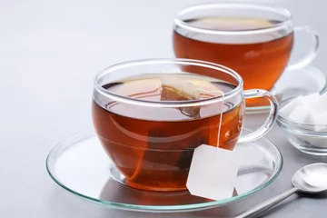 Fototapete Tee Tasse Tee mit Teebeutel auf grauem Hintergrund.  © vitals