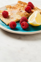 Folded pancakes on white marble background