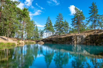 Fototapeta na wymiar Old open pit mine with crystal clear turquoise water