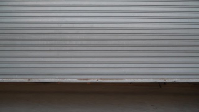 factory door is closing.background of the sliding and dirty steel sliding door is closed.