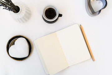 Valentine's Day composition. Female desktop with cup of coffee and plate with heart shaped ginger cookie on white background. Valentines Day celebration concept