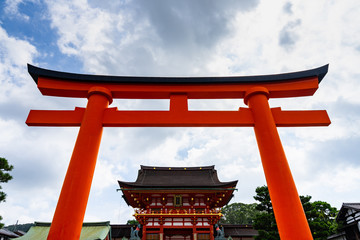 Big orange torii gate at the entrance of Fushimi Inari, the most famous shrine in Kyoto, Japan.