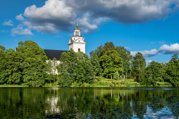Fototapeta na wymiar Beautiful white church surrounded by lush foliage