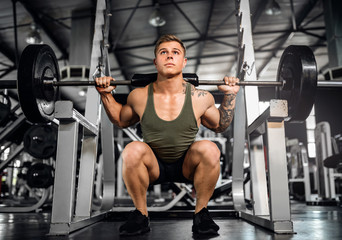 Fototapeta na wymiar Young attractive muscular gen z body builder doing back squats
