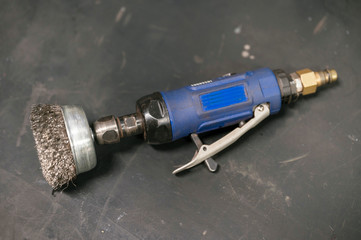 Air rotary grinder with metal brush.