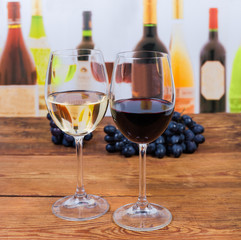 Two glasses of red and white wine on rustic table