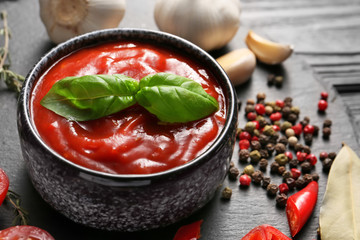 Bowl with tomato sauce on table